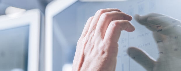 männliche Hand zeigt auf einen Computer Bildschirm